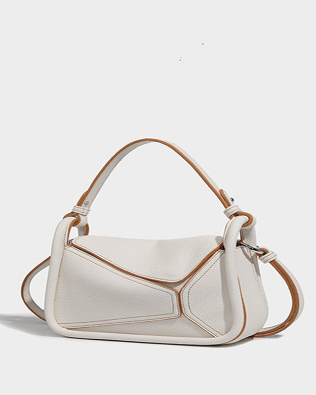 White handbag with brown accents on a light gray background