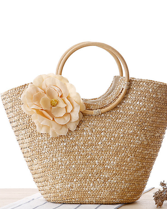 Woven straw bag with floral detail on a white background