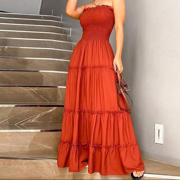 Woman wearing a red dress standing in front of a staircase.