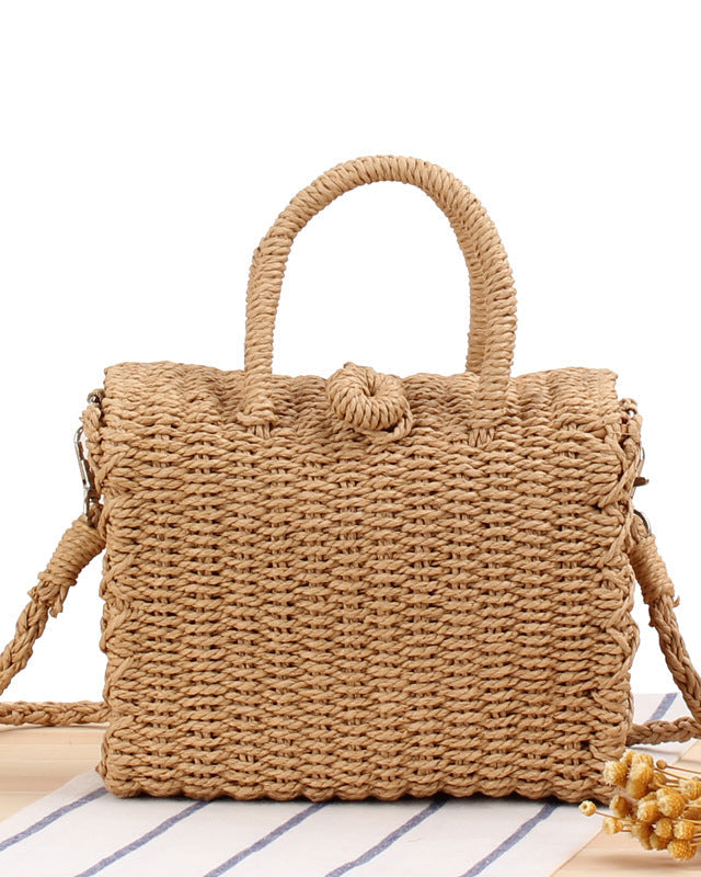 Woven straw bag with handles on a white background