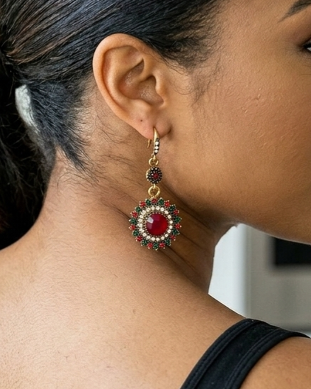 Close-up of a woman wearing a red and gold earring.