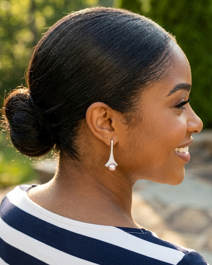 Woman with a styled hair bun wearing earrings outdoors