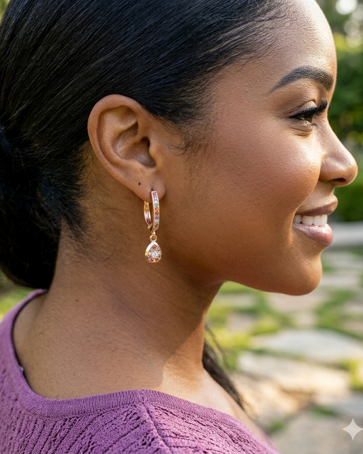 Woman wearing gold earrings with a blurred outdoor background