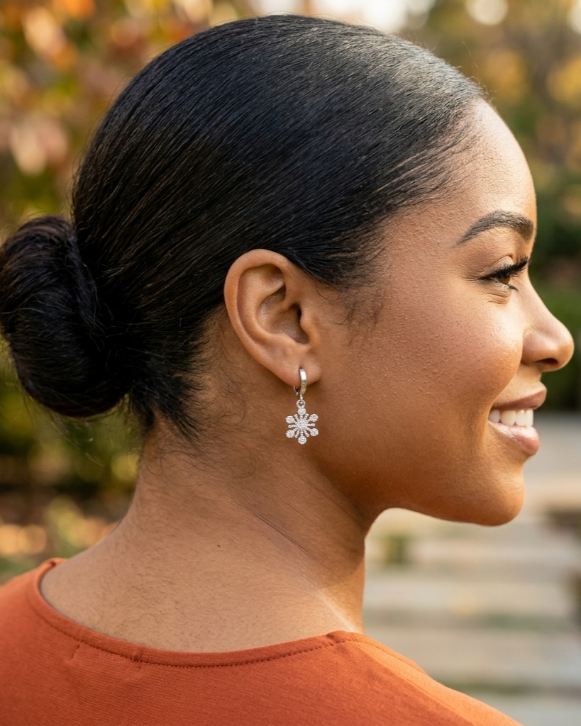 Woman with a bun wearing a snowflake earring outdoors