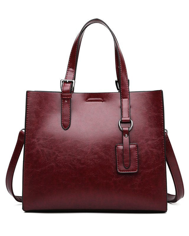 Red handbag with a shoulder strap on a white background