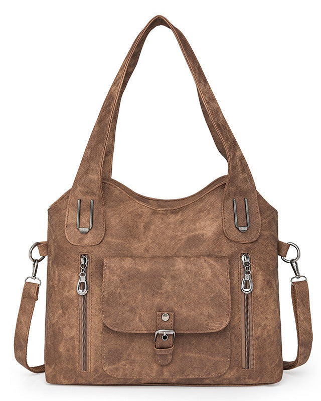Brown leather handbag with multiple pockets and straps on a white background