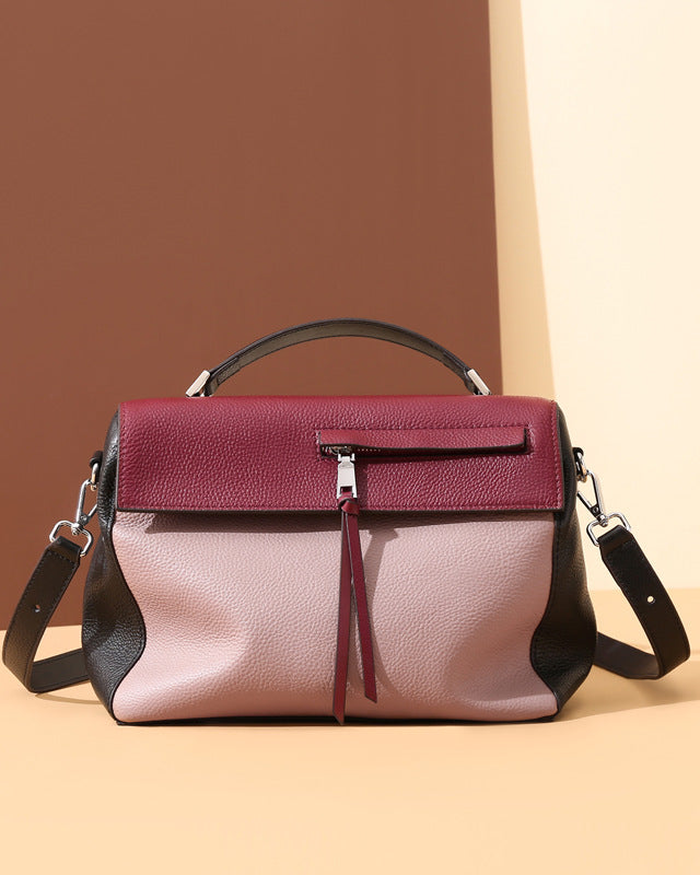 Two-toned handbag with maroon top section and pink bottom section on a two-tone background