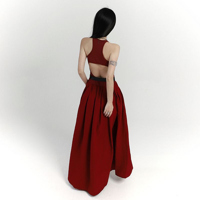 Woman wearing a red dress with an open back on a white background
