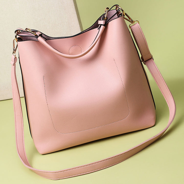 Pink handbag with a strap on a light green background