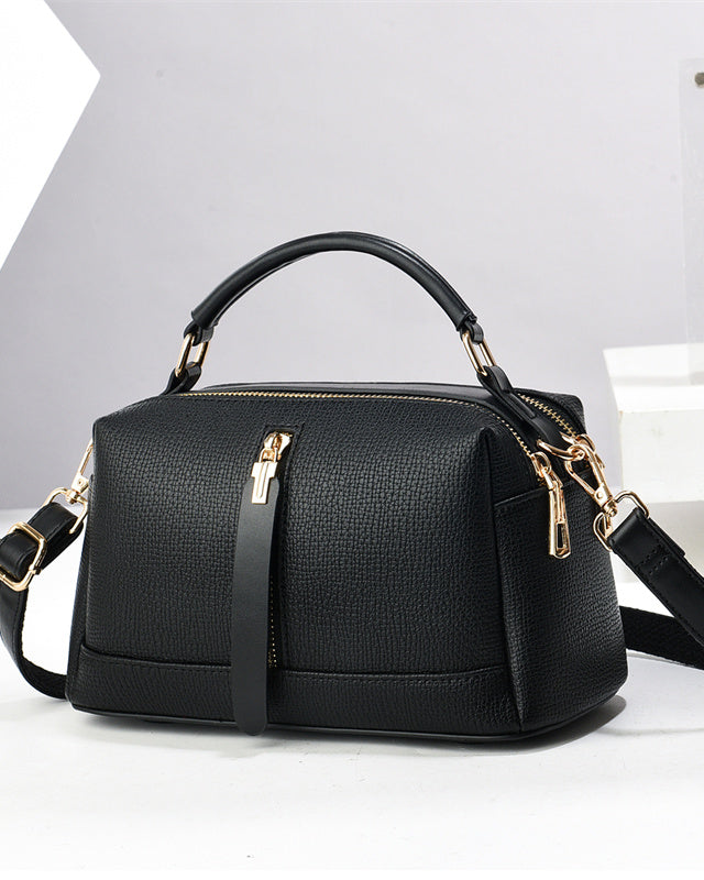 Black handbag with gold accents on a white background