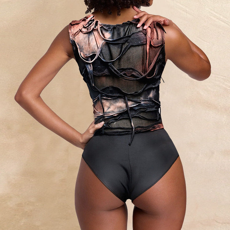 Person wearing a black bodysuit with sheer panels against a beige background