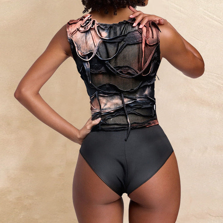 Person wearing a black bodysuit with sheer panels against a beige background