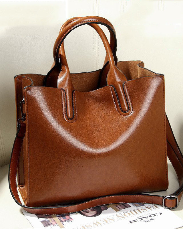 Brown leather handbag on a light background