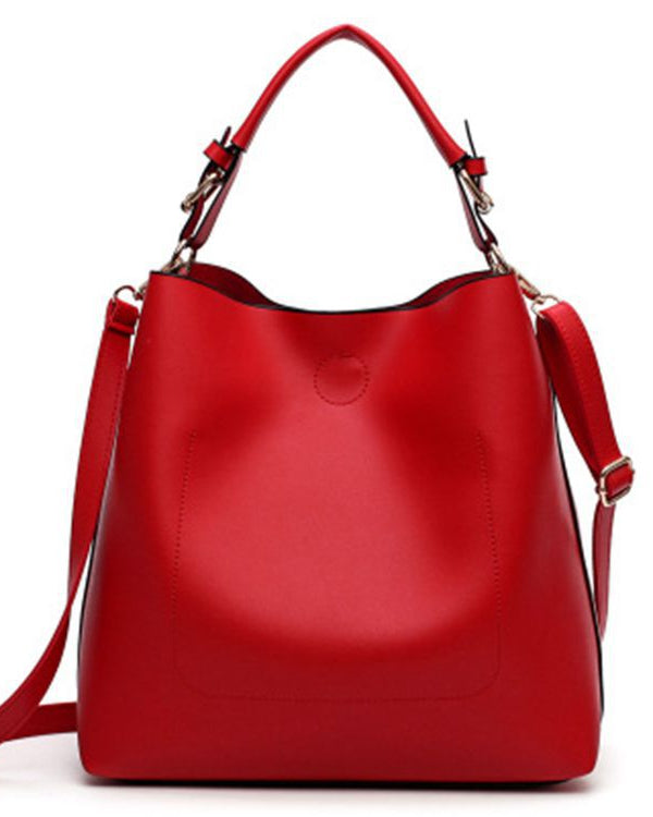 Red handbag with a strap on a white background