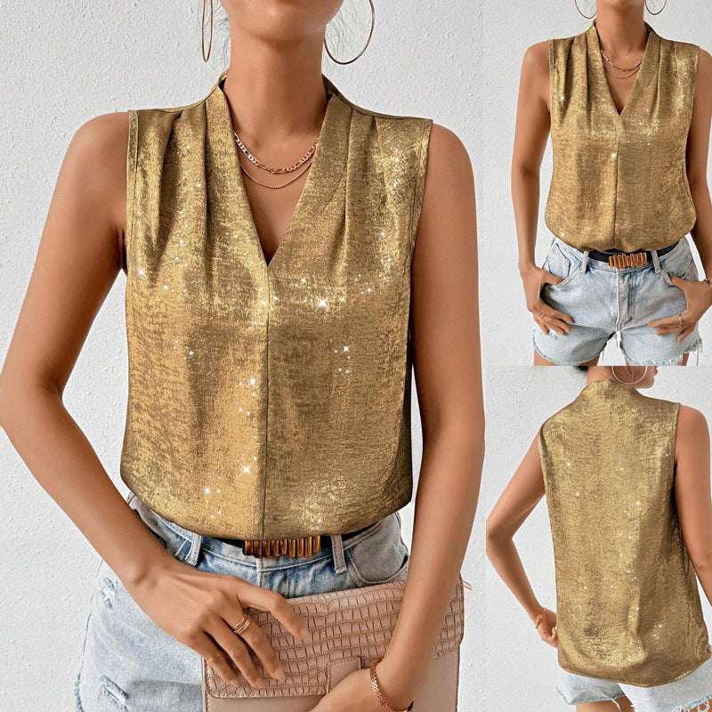 Woman wearing a gold sleeveless top with denim shorts and a brown handbag.