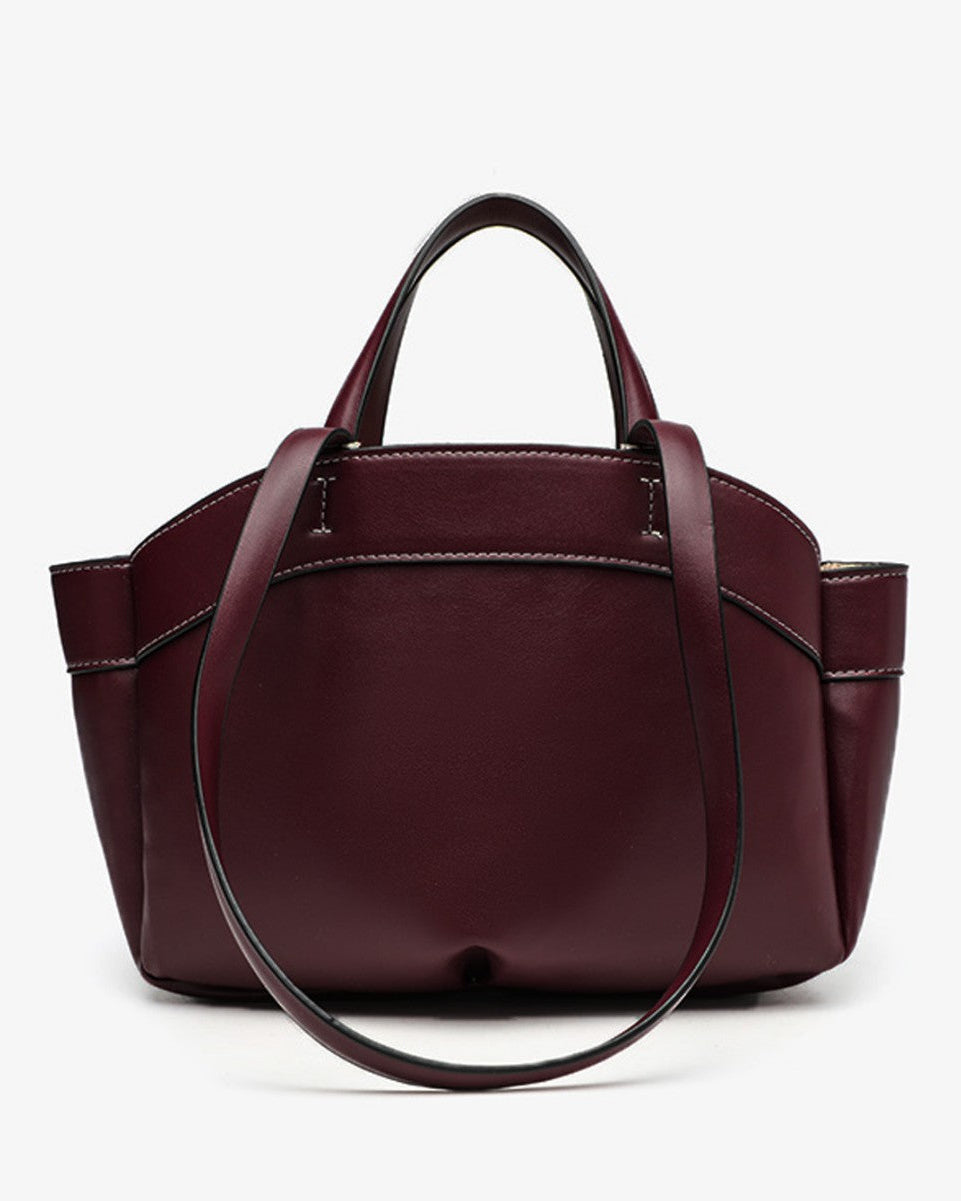 Burgundy handbag with a strap on a white background