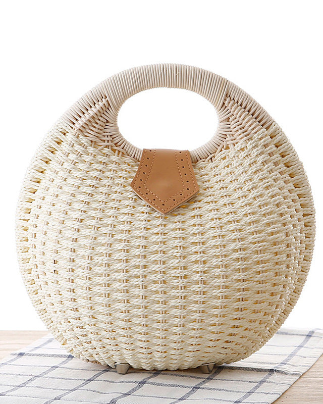 Round woven handbag with a leather tag on a checkered tablecloth