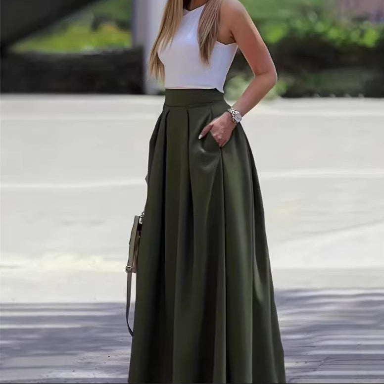 Woman wearing a white top and green skirt with a blurred background