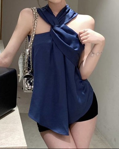 Woman wearing a blue top and black shorts in a bathroom setting