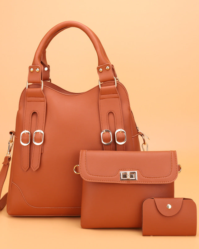 Brown leather handbag set with matching wallet and small pouch on an orange background