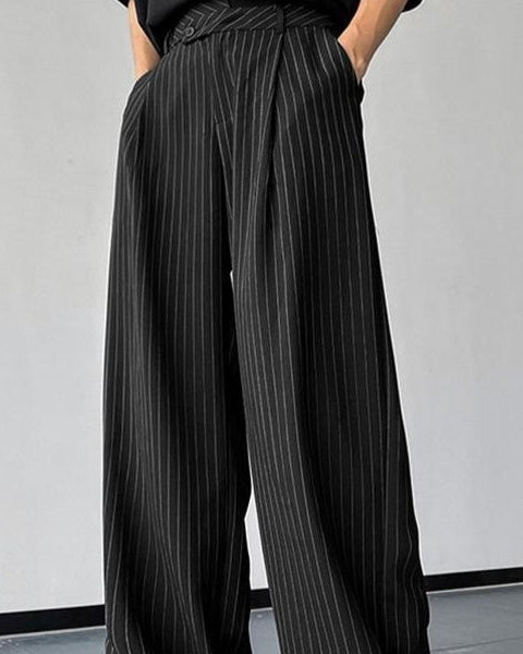 Person wearing black pinstripe wide-leg pants against a plain background