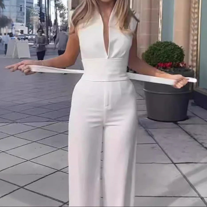 Woman in a white jumpsuit holding a white hoop on a city street.