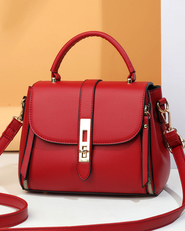 Red handbag with a strap on a white background