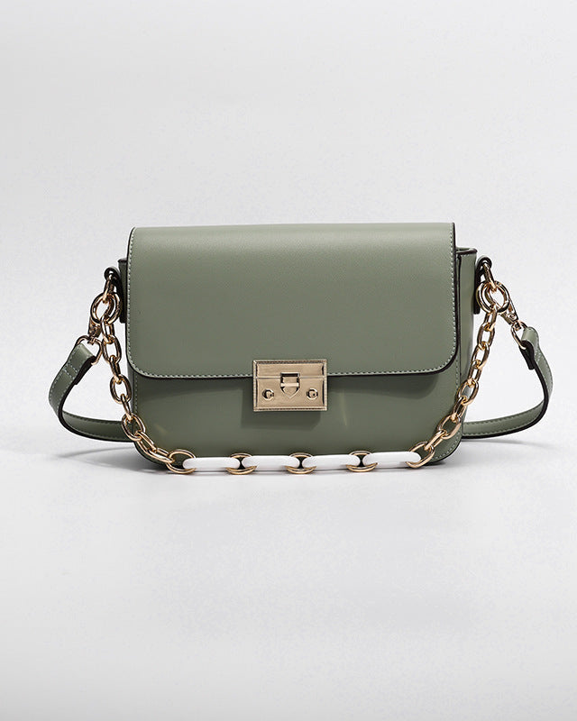 Green handbag with a chain strap on a light gray background